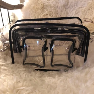 Nuuno transparent bag  - En äkta nuuno väska transparent. Tillkommer ett långt band och ett kort band, det långa bandet kan man ta av. Frakt tillkommer.PRIS KAN DISKUTERAS