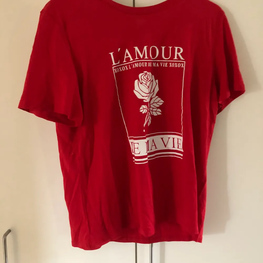 En söt röd t-shirt med ett vitt tryck på. Använd endast en gång. Storlek L men passar både mindre o större storlekar. Köparen står för frakten.. T-shirts.