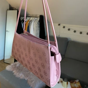 Rosa axelväska - Säljer min superfina vintage inspirerade axelväska!🥰 Det är dock slitning vid handtaget men det är inget man tänker på💘 (tredje bilden) buda i kommentarerna vid intresse! Bud: 150