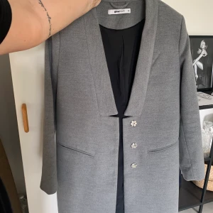 Grå kappa  - Grå kappa i strl 34, köpt från ginatricot för flera år sedan.  Skulle säga att den är lite större i storleken, samt rak i modellen. 