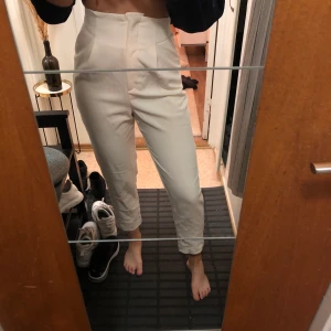 Vit-beiga kostymbyxor - Highwaist kostymbyxor, vit-beiga. Sitter tight i midjan och rakare modell på benen. Lite ostrukna på bild men det går ju givetvis att lösa! Strl 34