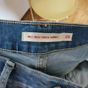  SUPER SKINNY Levis stl. 26 - Har ett par oanvända MILE HIGH SUPER SKINNY levis jeans, köpta sen förra året. Storlek 26 med stretch. Oanvända pga felköpt storlek. Ordinariepris 1149, nu endast 500 kr