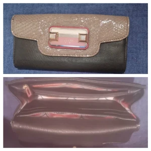  - Stor äkta Vintage GUESS Palermo Svart/Multi Plånbok/Clutch med mycket utrymme.Framsidan GUESS EST. 1981 metal emblem rosa/guld. Ett stort fack på baksidansidan. Inuti ett fack med blixtlås med Guess emblem på draget. Plats för 6 kreditkort på framsidan . Inuti 3 större fack och plats för 8 kreditkort. Stängs med trycknapp. Övriga detaljer i ljust guld och grå "krokodil skinn"  Material; 100% PU/Faux läder Mått; B 20 cm, H 10 cm, D 3cm I bra skick med normala spår av användning .  Inköpt längesedan ca 1000 kr Säljs 250 FRAKTFRITT. Priset kan diskuteras vid en snabb affär.  Avhämtning i Södertälje /Skickar fraktfritt . Swish. Titta gärna på mina andra annonser. 10% av det jag säljer ger jag till välgörenhet genom targetaid.com, skickar screenshot med donationen 😊 