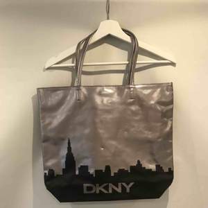 Supersnygg silvrig väska med svart stadssilhuett på från DKNY! Säljer eftersom den får alldeles för lite uppmärksamhet i min garderob.