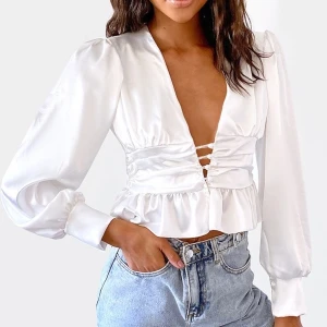 Vit PLT topp  - Supersnygg vit topp från pretty little thing! Satinliknande material. Säljes pga för liten! Storlek UK 8 vilket motsvarar 36. Pris inkl frakt är 170 kr.