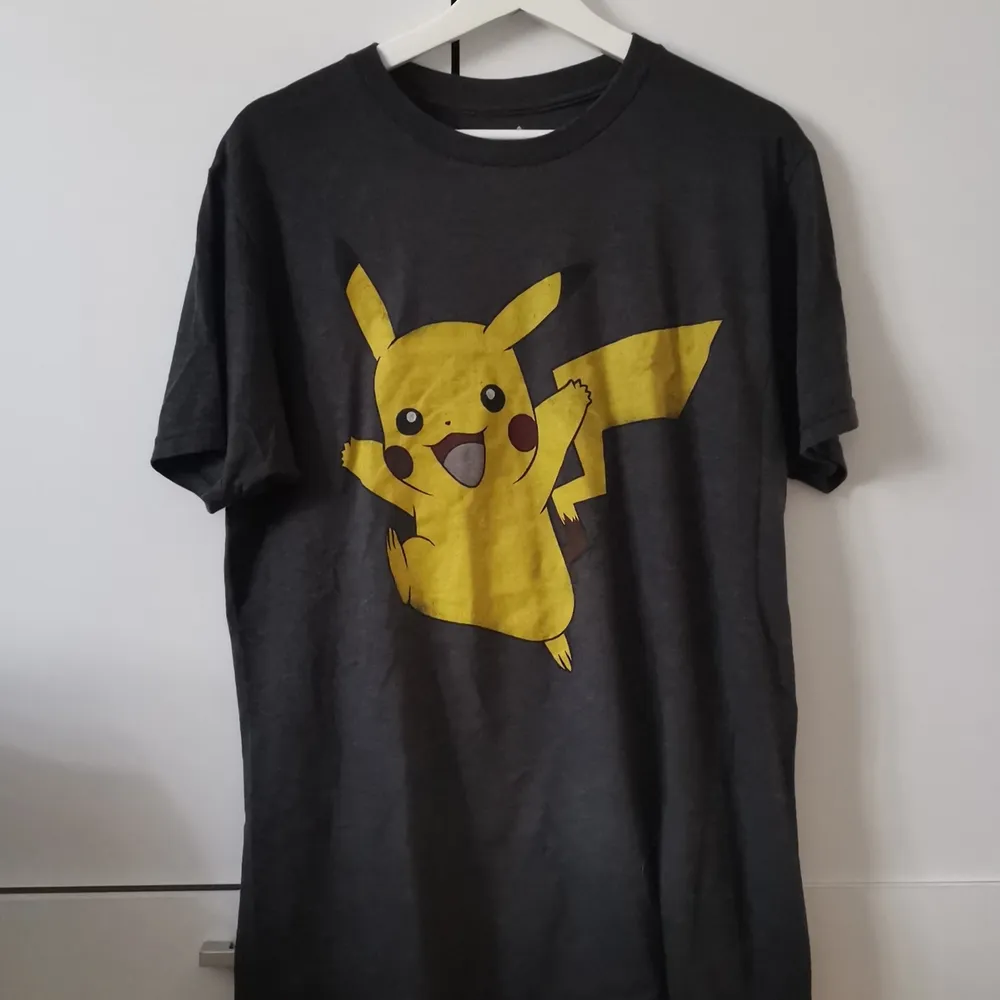 Grå T-shirt med Pikachutryck i storlek M (herravdelningen). Frakten ligger på 44 kr. . T-shirts.