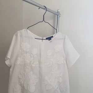 Tröja med tryck  - En vit blus med diskret blomtryck   