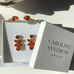 Caroline Svedbom smycken  - Caroline Svedbom smycken. Orangea örhängen 500kr , armbandet 300kr och grå örhängena 200kr. Eller alla för 800kr
