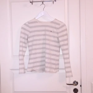  - Silvrig/vit randig Tommy hilfiger tröja med två småhål i sig :/