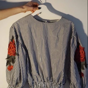  - Blus med pösiga armar med broderade blommor. Köpt i Tokyo och aldrig använd (lapp hänger kvar).