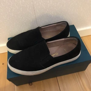  - Svarta mocka slip-ons från märket Dasia i storlek 38. Nypris 899 kr
