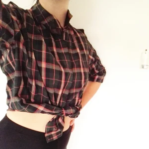  - Snygg rutig bomullsskjorta! Funkar båda som knyttopp och vanlig skjorta. Bild två visar halsknäppningen och sömmen vid axlarna, bild två visar också bäst på färgerna. En av knapparna saknas, därför det låga priset! Jag tycker inte det gör något dock, den funkar bra att knäppa ändå :)