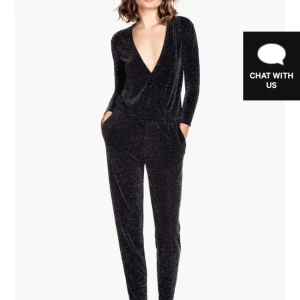  - Jumpsuit med omlott i glittrig material, resårband i midjan som gör att den sitter på plats