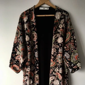  - Mönstrad kimono i velvet från mango. Fransar längst ner, tjockt tyg och hänger fint pga av tyngden. Använd två gånger men mest hängt på vägen som prydnad, så någon har nog mer användning av den. Bra skick.   Swish funkar och köparen står för frakt, kan även hämtas upp i Malmö. 