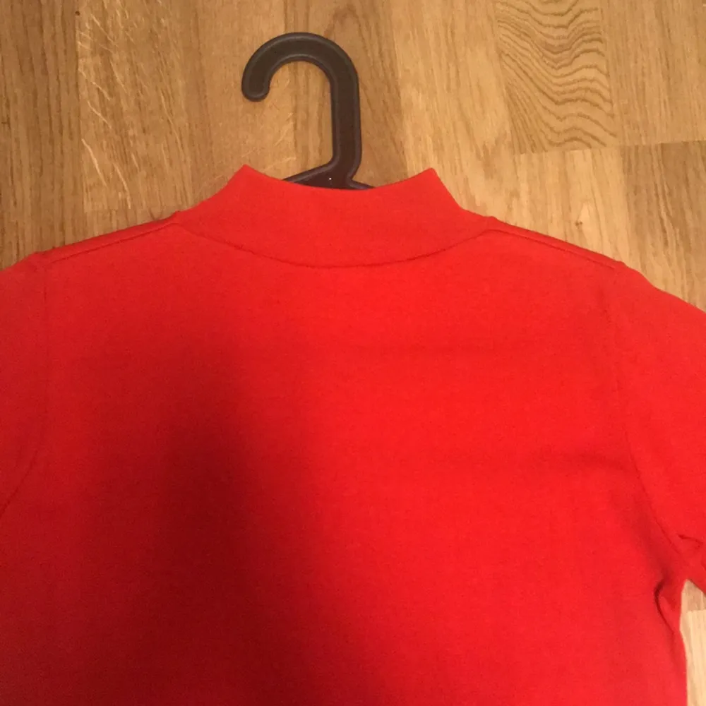 Second hand Röd tröja med hög krage i stl M.. Toppar.