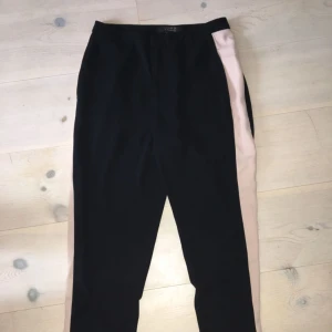  - Kostymaktiga byxor med en beige rand på båda sidorna av benen