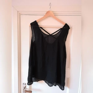  - Tunn svart topp med korslagda band på ryggen 