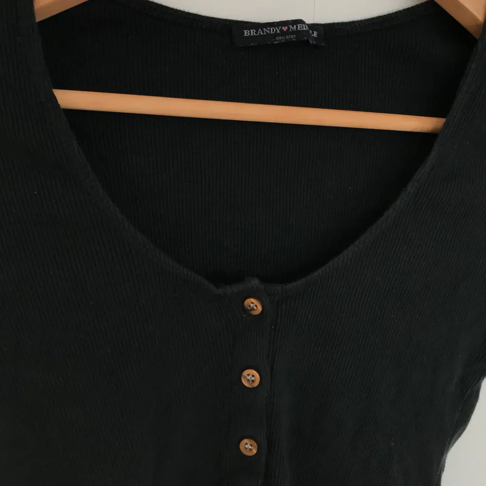 FIN ribbad svart långärmad tröja med bruna knappar från Brandy Melville! Superfin! 🍸. Toppar.