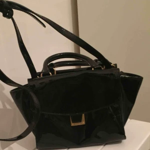  - Lackväska med axelrem, små fickor och fina detaljer