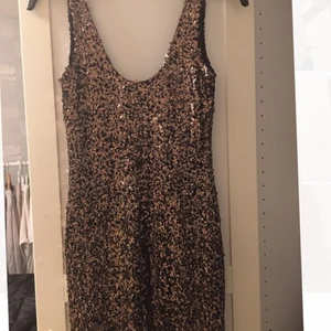 Paljettklänning - Paljettklänning i guld/svart perfekt till nyår!  Säljs för 100 + frakt. Fler bilder kan skickas om så önskas.