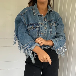 Jeansjacka - Jättesnygg jeansjacka från Bershka med fransar över ryggen och armarna🤩🤩Storlek S men är oversized på modellen som kan är S/M. Frakt tillkommer💕