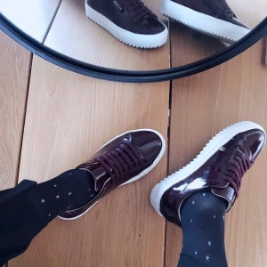 AXEL ARIGATO Platform Sneaker 36 - Sneakers från AXEL ARIGATO i toppskick. Använda ett fåtal gånger. Inga märken eller skavanker. Grov sula i gummi. Ovansida i glansig/lackad stil i vinrött/burgundy. Storlek 36. Dust bag medföljer. Nypris ca 2200:- 
