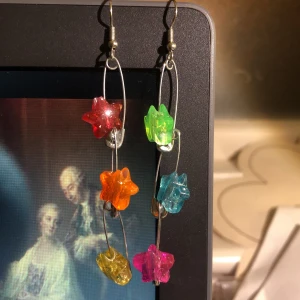 stjärnörhängen!! - örhängen av säkerhetsnålar med stjärnor i regnbågens färger<3 frakt tillkommer med 11kr