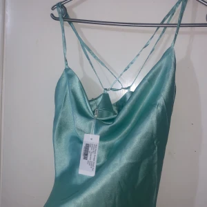 Storlek 34 - Helt ny turkos  linne med massa band 