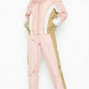 NLY Trend Luxury Track Pants and Jacket - En pink Luxury Track Pants(st34) and Jacket(st36) från Nelly, som är helt ny och oanvänd. Kan köpas både som ett set och som separata delar. Vid köp som set 650kr och vid köp som separata  delar 350kr var.