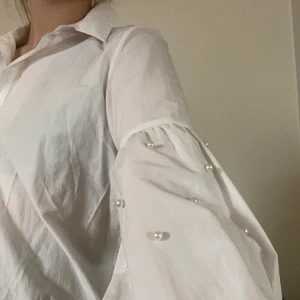 Lite kortare skjorta med pärlor - Vit skjorta med pärlor på ärmarna från zara, skrynklig på bilderna men ser självklart bättre ut när den är strykt 