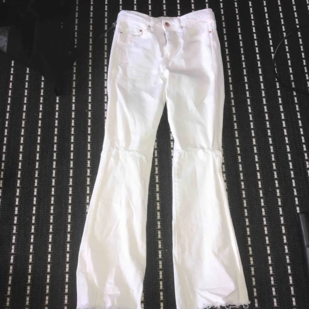 jätte fina vita bootcut jeans med slits vid knäskålen den är i jätte bra skick används bara 2 gånger den passar 150-155cm. frakt ingår ej. Jeans & Byxor.