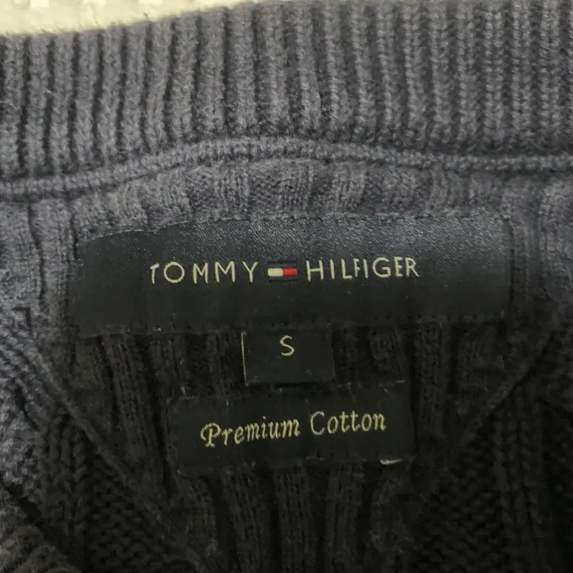 Marin blå Tommy Hilfiger stickat tröja i storlek S för män. Produkt i god form, gjord av 100% bomull, varm och passar bra under höst/vinter. Logo vid vänster hand. Tvättinstruktioner (maskintvätt). Stickat.