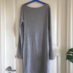  - Långärmad grå klänning med djup urringning bak från märket club L (köpt på nelly). Frakt på 49kr tillkommer!