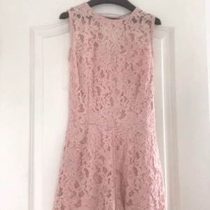 Ljusrosa playsuit storlek 34 - Använd tre gånger så den är i bra skick. Den är öppen i ryggen vilket är väldigt fint på sommaren. Den har en underdräkt som gör att man inte ser igenom. Vid intresse kan jag antingen mötas upp i Stockholm eller frakta - köparen står för frakten