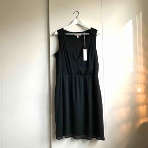Svart klänning ESPRIT - > OANVÄND <  En svart oanvänd klänning från Esprit. Små svarta diskreta prickar i tygmönstret. Nypris 699kr säljer för 80kr.    Köparen står för portokostnad. 