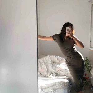  - Figurnära midi-klänning i militärgrön färg.