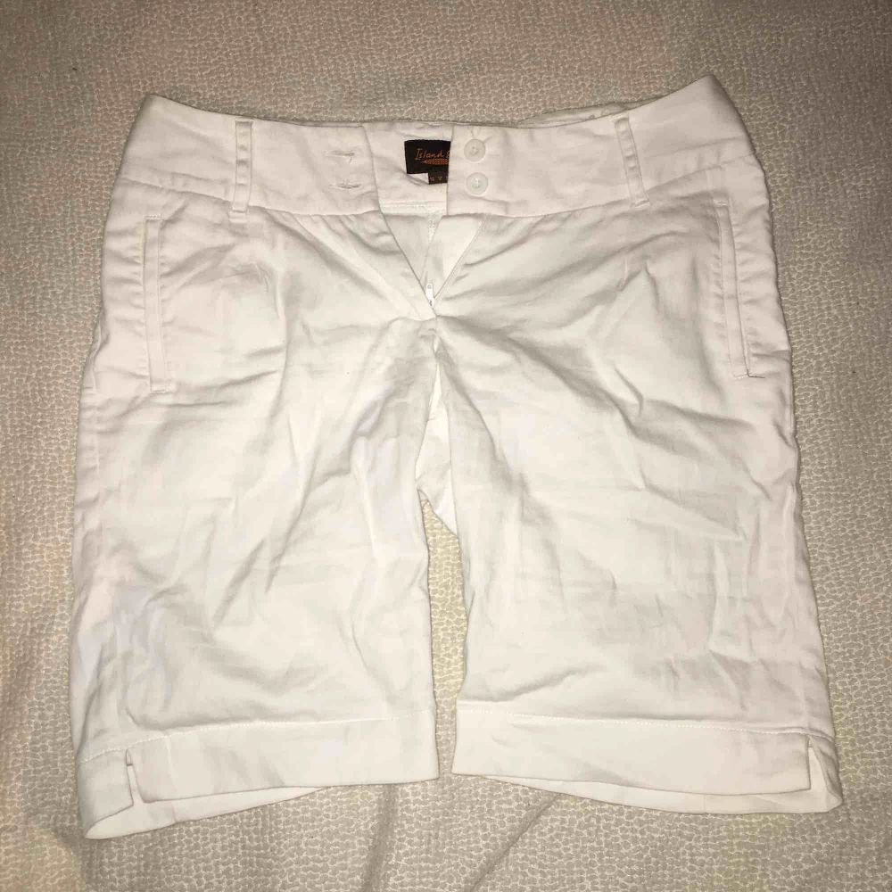 Vita shorts från Island Shop med två vita knappar och en dragkedja på framsidan. . Shorts.