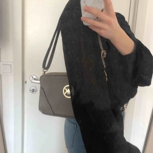 Grå väska - En fin grå fake MK väska med många fack och stora utrymmen! Aldrig använd och går att justera bandet💕 