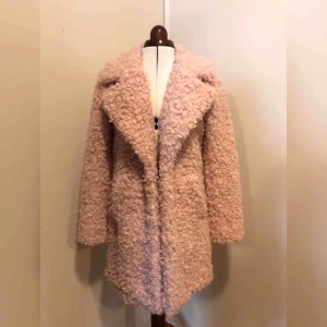  - Underbar fuskpäls i ljusrosa med vackert mönstrat foder. Knäpps fram med hylsor. Köpt för 979kr. Passar perfekt som vårjacka!   PS jag har två likadana pälsar i stl xs & s, därför har jag två annonser uppe! Xs använd en gång, s aldrig använd:) 