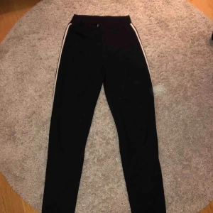  - Ett par byxor från ginatricot med vita ränder på sidorna. Köpare står för frakt