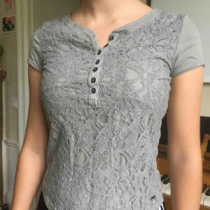  - Mkt fin top med spets fram o knappar i urringningen. Gråbeige/mullvad. 