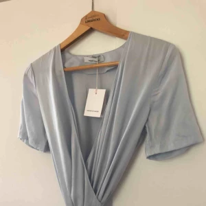  - Helt ny ljusblå Samsøe omlottklänning i storlek XS. Får inte med hela längden på bilderna pga kvadratformat, men fråga om fler bilder! Superfin och hög kvalitet. Nypris är 1399 kr. Prislapp kvar, helt oanvänd. Köpare står för frakten