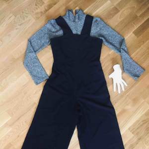 Svart Jumpsuit med tight midja & vida ben, & med blixtlås baktill.  Använd endast ett par gånger.  Mått midja 37cm (rakt över) Längd (axel till benslut) 139cm