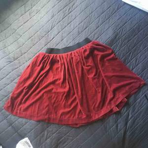 Vinröd kjol från monki i velour tyg, den har ett litet märke på sig men den syns inte då kjolen hänger veckad.