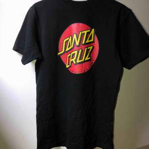 Svart t-shirt från Santa Cruz skateboards med vanliga loggan på framsidan. I bra skick, använd 10-20 gånger. Köpt får mer än två år sedan, säljer pga att den aldrig används.🌷 köparen står för frakt, betalas med swish