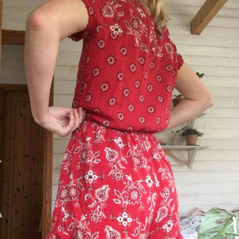 Röd blommig jumpsuit från hollister, knappt använd . Klänningar.