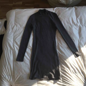  - Tight klänning i mörkare grå. Strl. S men passar även XS och M då det är ett väldigt stretchigt material. Halv Polo. Använd en gång. Köpt för 500kr. Betalning sker via swish 