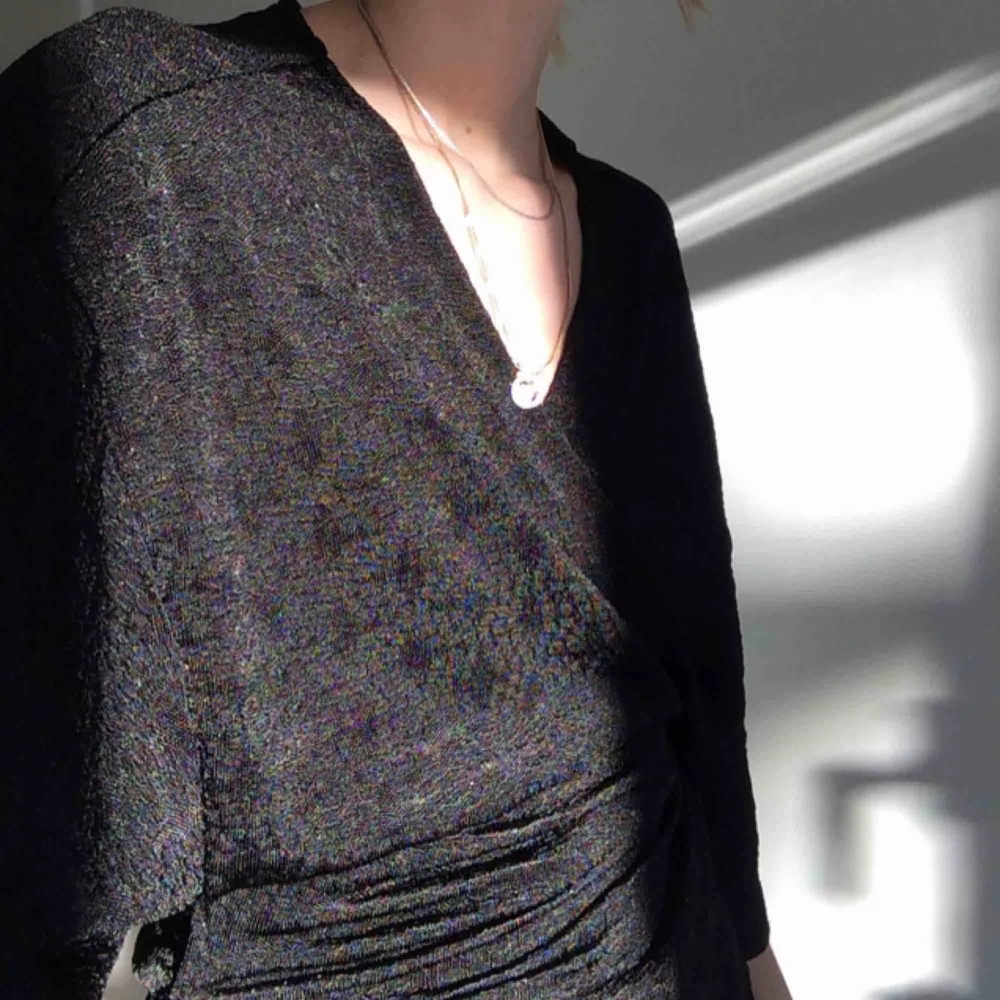 Svart omlottblus/kimono top i skönt material med lite snygg struktur i tyget, se bild 2. Väldigt sparsamt använd! Perfekt till vardags eller festliga tillfällen året runt🌟 . Blusar.