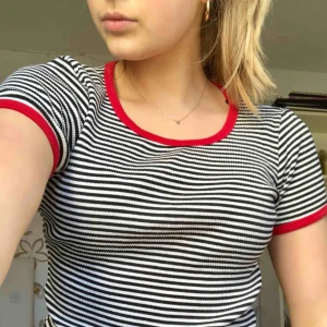  - Svart och vit randig t-shirt men röda detaljer. Köparen står för frakt ☺️