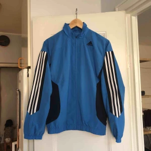  - En trackjacket från Adidas. Storlek 36/small, damstorlek. Skick: 6.5/10. Levereras nytvättad. Finnes på Södermalm, Stockholm. Kan postas men då står Du för frakten, (54kr). Mvh Marija & Nugget